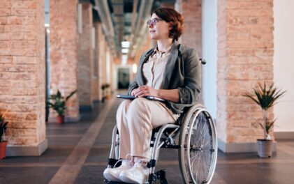Frau sitzt im Rollstuhl.