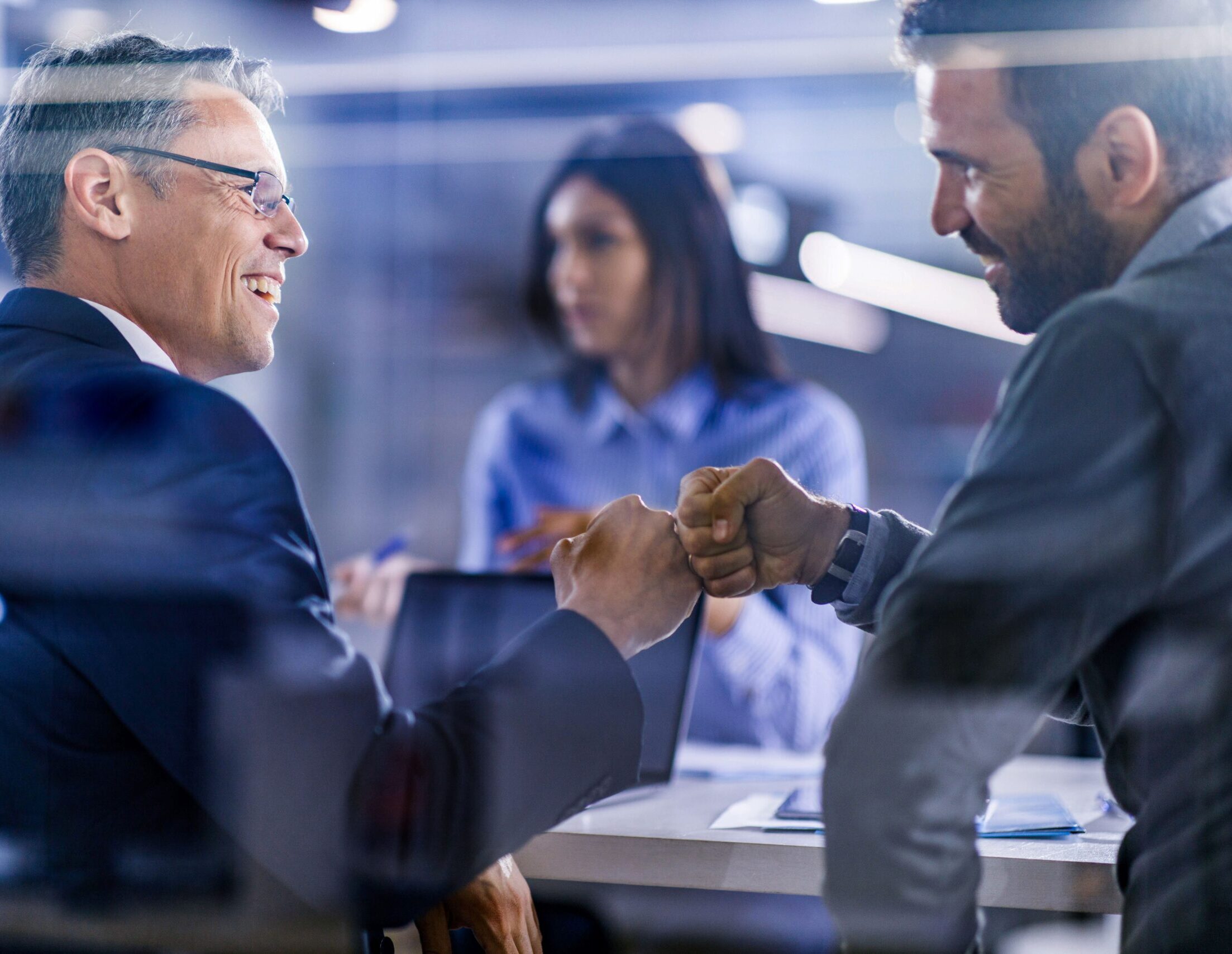 Ein Arbeitgeber und ein Mitarbeiter geben sich einen Faustgruß.