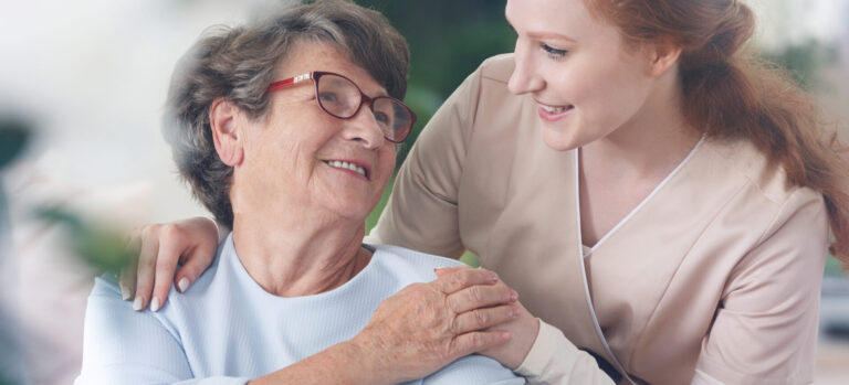 Eine ältere Frau wird von einer Pflegekraft betreut – ermöglicht durch die Unterstützung ihrer Krankenversicherung.