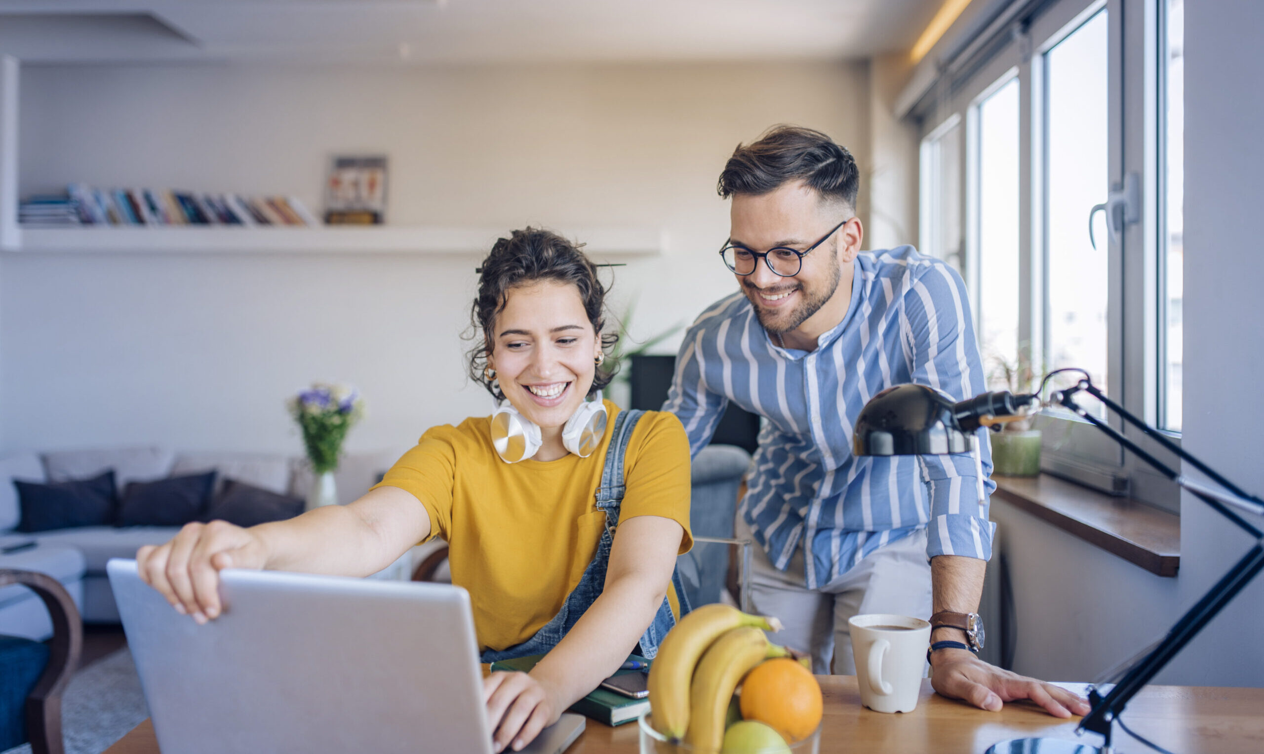 Ein Mann und eine Frau informieren sich gemeinsam am Laptop über die Vorteile des betrieblichen Gesundheitsmanagements.